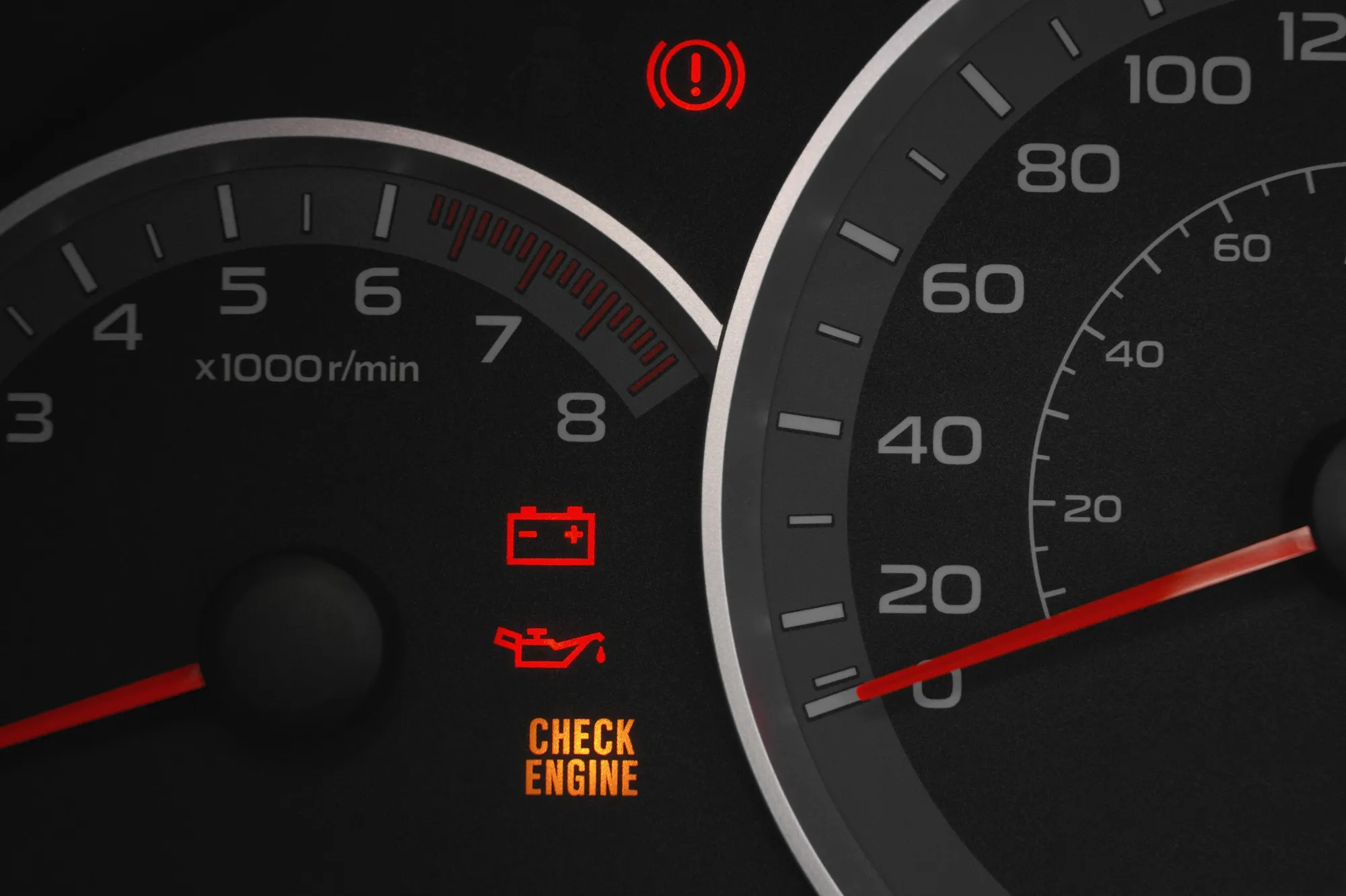 Car dashboard gauges with red brake, battery, and oil warning lights and an amber check engine light illuminated.